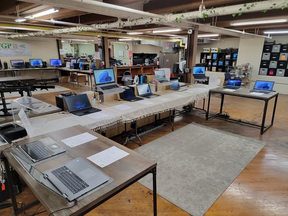 Laptops arranged on display tables inside Free Geek Penn